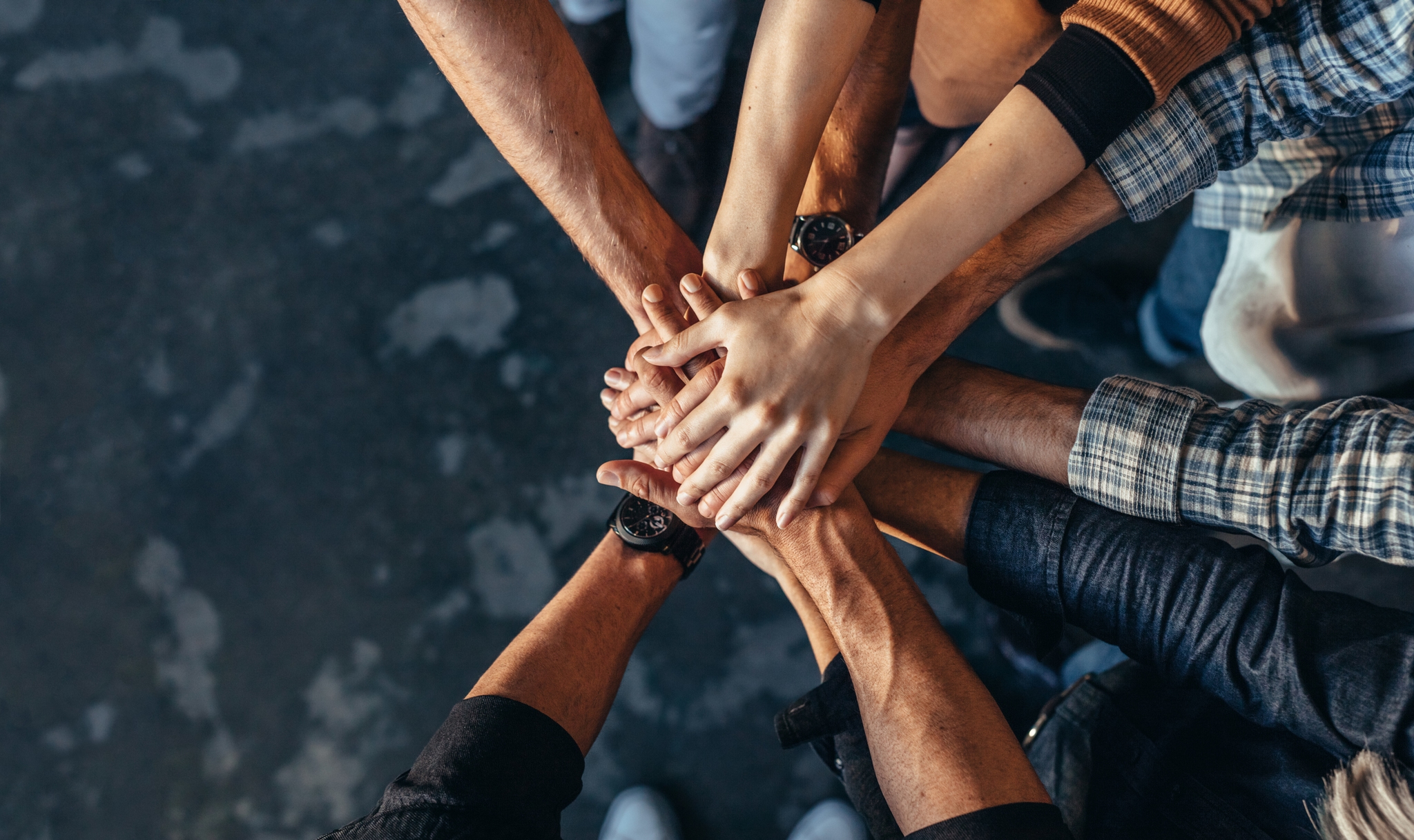 Cohésion d'équipe · mains empilées en signe d'unité