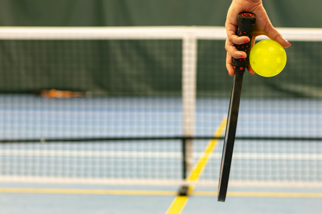Détail d'une raquette de Pic​kleball et de la balle perforée
