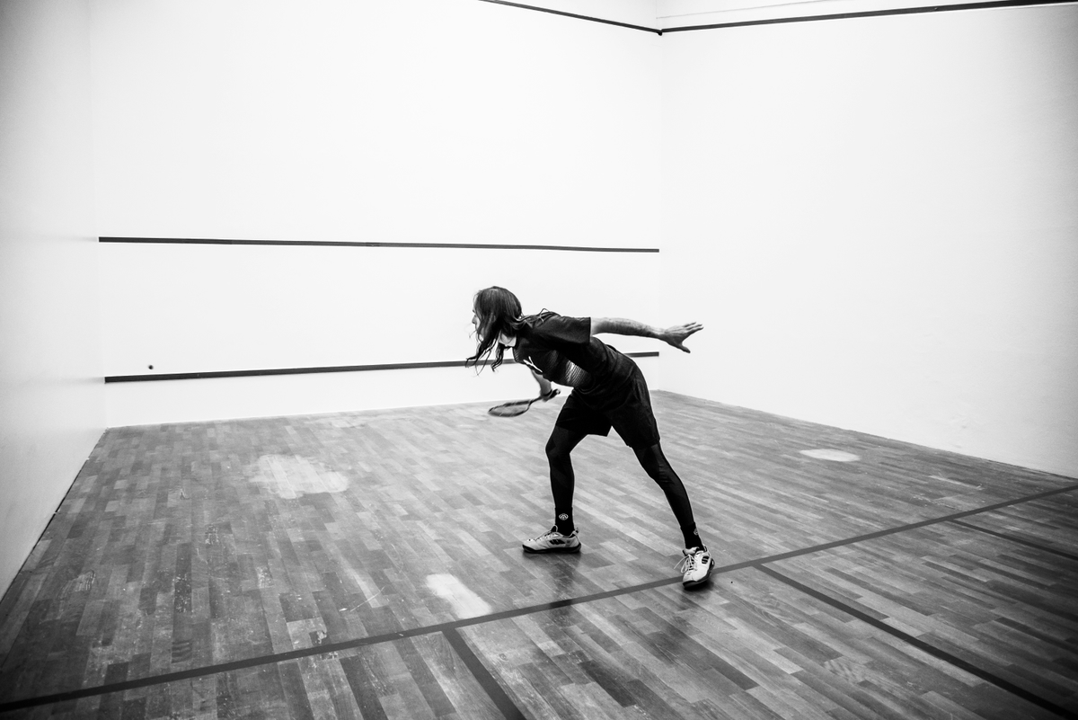 Joueuse en pleine action sur un court de squash