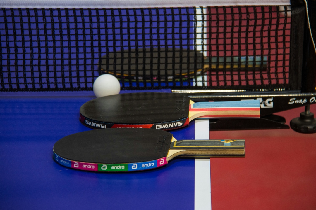 Détail d'une raquette de tennis de table et de la balle blanche