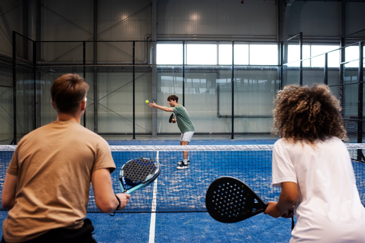 Ambiance sur un court de padel, joueurs en action